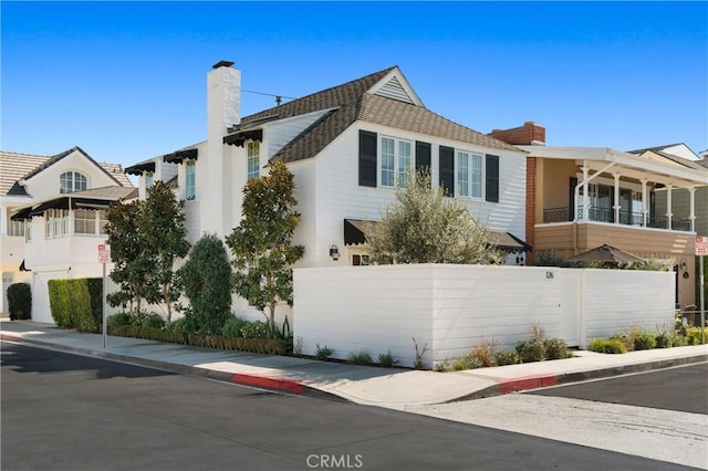 view of front of property with a chimney and fence