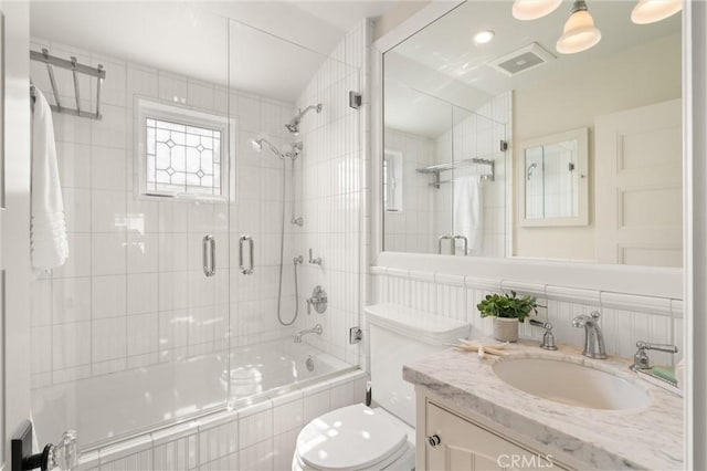 full bath with toilet, visible vents, tiled shower / bath, and vanity