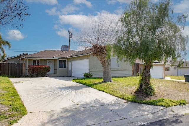 ranch-style home featuring a front yard, concrete driveway, fence, and an attached garage