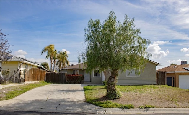 view of front of property featuring driveway and fence