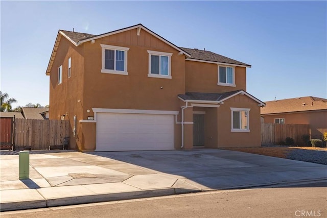 view of front of house with stucco siding, driveway, and fence