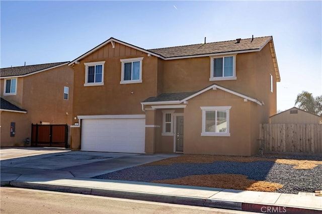 view of front of home with driveway, a garage, fence, and stucco siding