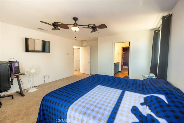 bedroom with carpet floors, visible vents, ceiling fan, and ensuite bath