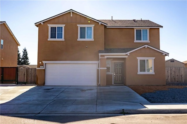 traditional home featuring driveway, fence, an attached garage, and stucco siding