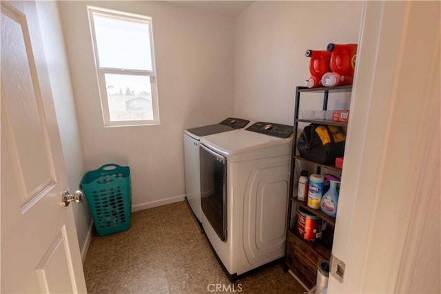 washroom featuring laundry area, separate washer and dryer, and baseboards