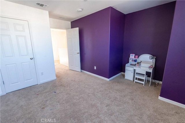 unfurnished bedroom featuring visible vents, light carpet, and baseboards