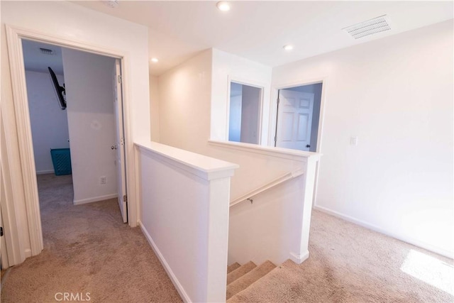 corridor with light carpet, an upstairs landing, visible vents, and recessed lighting