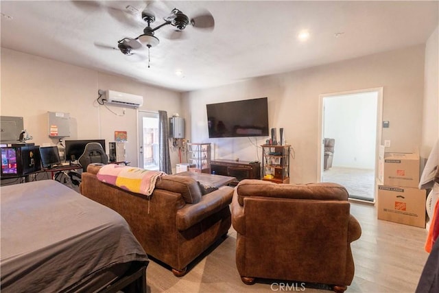 bedroom featuring a wall unit AC, light wood-type flooring, and a ceiling fan