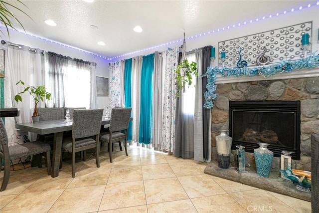 tiled dining room with a fireplace and a textured ceiling