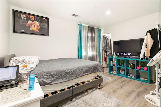 bedroom featuring wood finished floors and visible vents