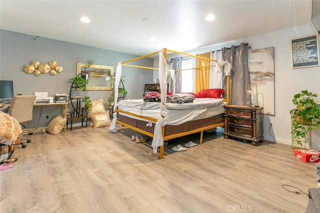 bedroom featuring baseboards, wood finished floors, and recessed lighting