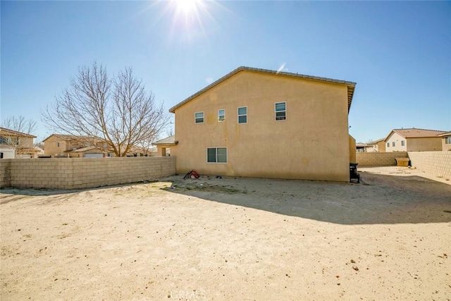 back of property featuring fence and stucco siding