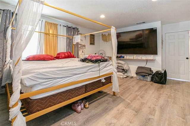 bedroom featuring recessed lighting, visible vents, and wood finished floors