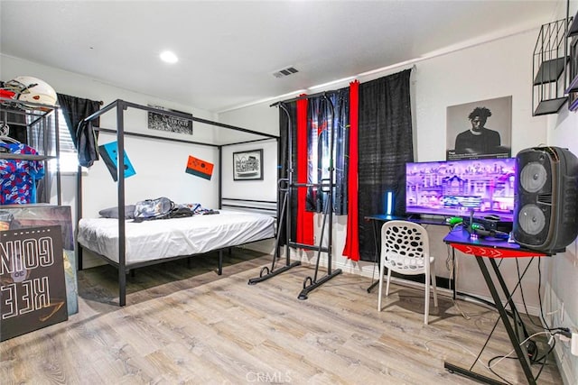 bedroom featuring wood finished floors and visible vents