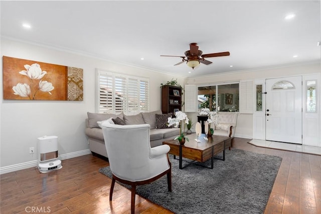 living room with dark wood-style floors, baseboards, ornamental molding, and ceiling fan