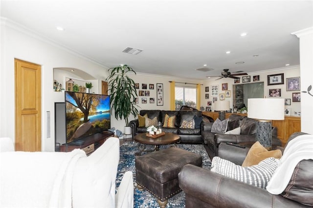 living area featuring arched walkways, recessed lighting, a ceiling fan, visible vents, and crown molding