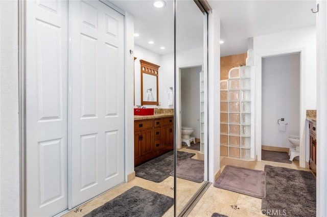 bathroom with a closet, vanity, toilet, and recessed lighting