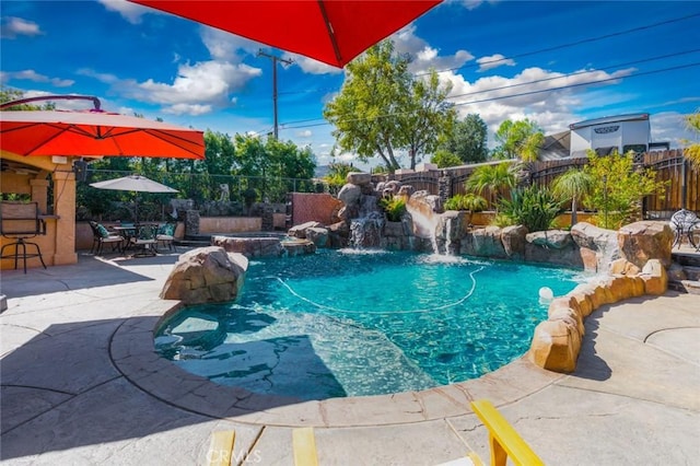 view of swimming pool featuring a patio, exterior bar, a fenced backyard, and a pool with connected hot tub