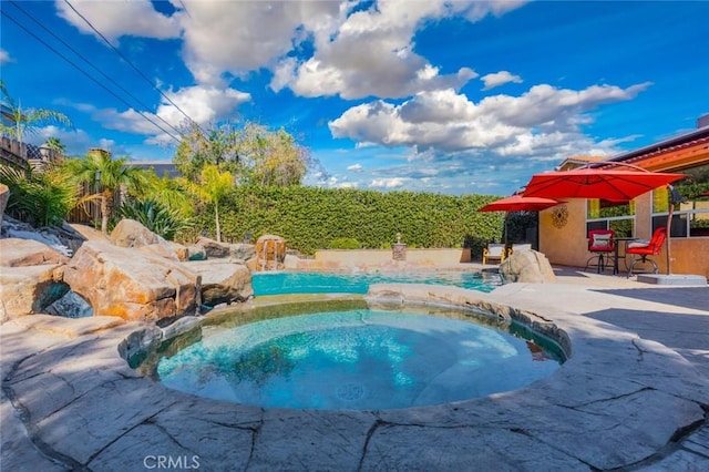 view of swimming pool with a patio area and an in ground hot tub