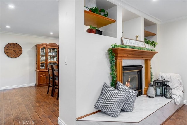 interior details featuring crown molding, baseboards, wood finished floors, and a high end fireplace