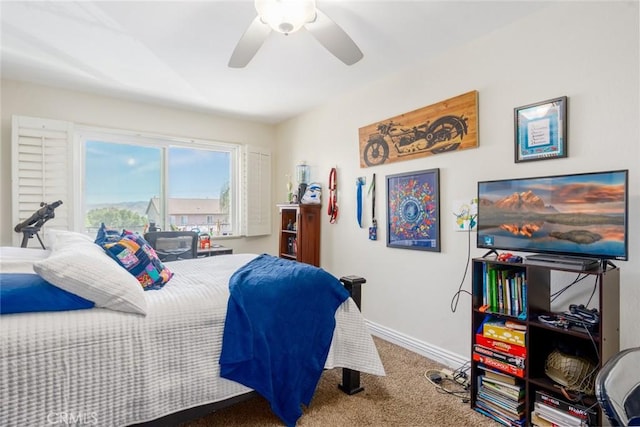 carpeted bedroom with ceiling fan and baseboards