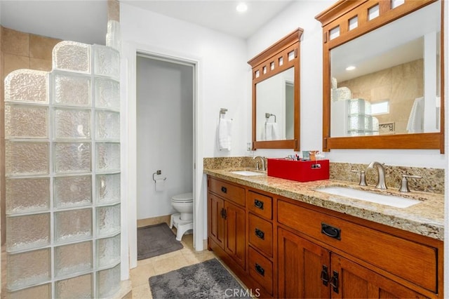 bathroom with tile patterned flooring, a sink, toilet, and double vanity