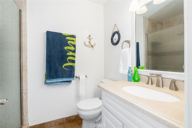 full bathroom with a stall shower, baseboards, vanity, and toilet