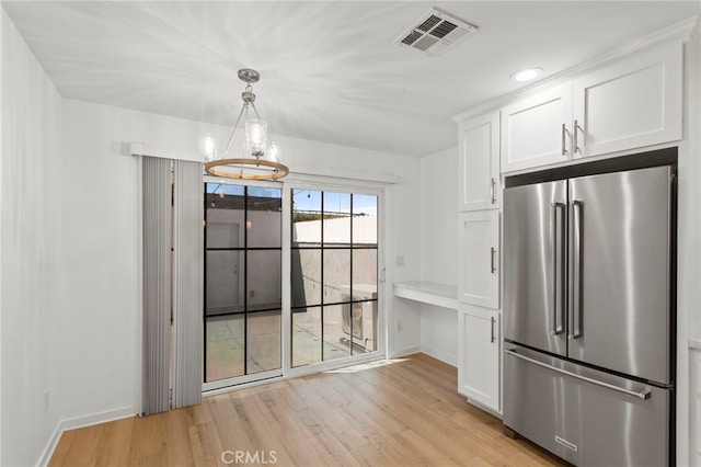 unfurnished dining area featuring visible vents, light wood-style flooring, and baseboards