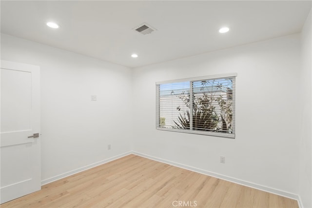 spare room featuring light wood-type flooring, visible vents, baseboards, and recessed lighting