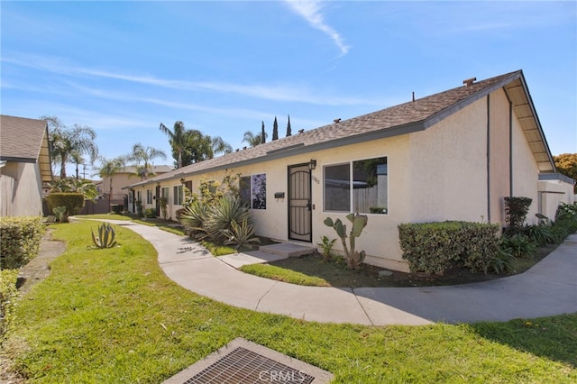 view of front of house with a front lawn and stucco siding