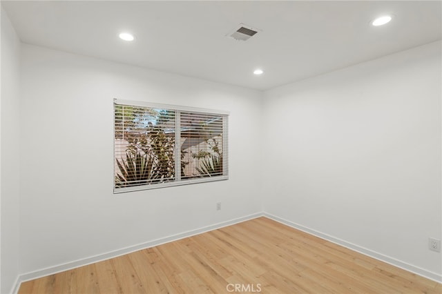 spare room with light wood finished floors, visible vents, baseboards, and recessed lighting