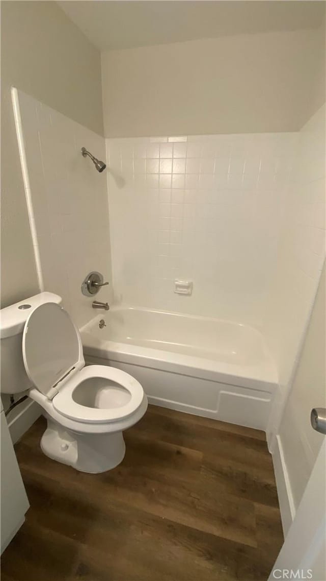 full bathroom with bathtub / shower combination, wood finished floors, and toilet