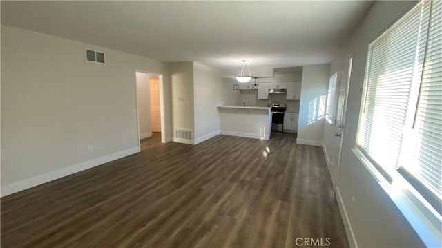 unfurnished living room with dark wood-style flooring, visible vents, and baseboards