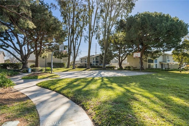 view of property's community with community basketball court, a yard, and a residential view