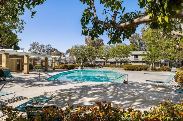 community pool featuring fence, a pergola, and a patio