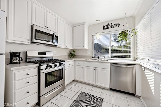 kitchen with white cabinets, decorative light fixtures, stainless steel appliances, light countertops, and a sink