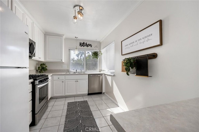 kitchen featuring stainless steel appliances, a sink, white cabinetry, hanging light fixtures, and light countertops