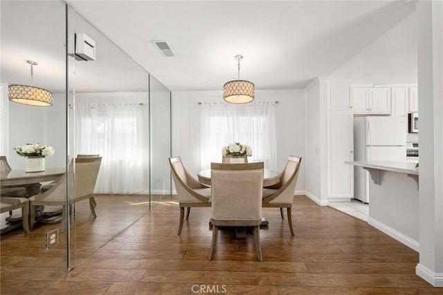 dining room featuring visible vents, plenty of natural light, and wood finished floors