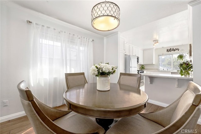 dining space with baseboards and wood finished floors