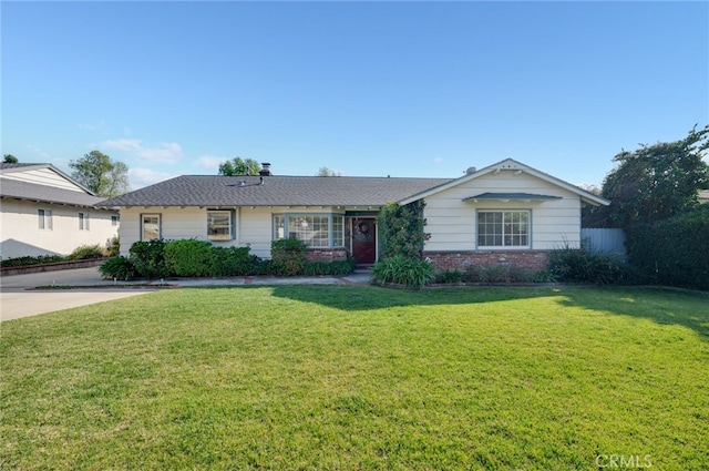 ranch-style home featuring brick siding, a front yard, and fence