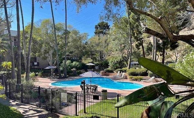 pool featuring fence and a patio