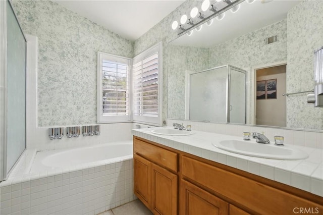 bathroom featuring a bath, wallpapered walls, a sink, and a stall shower