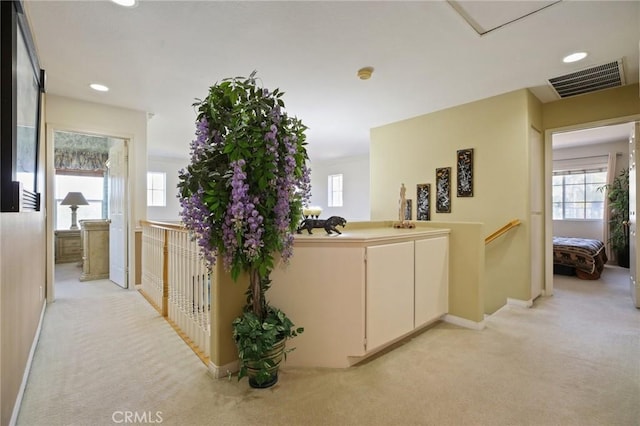 hall featuring light carpet, recessed lighting, visible vents, and an upstairs landing