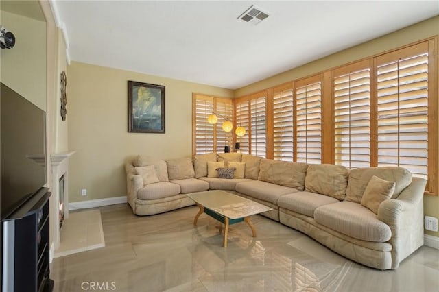 living room with visible vents, a fireplace, and baseboards