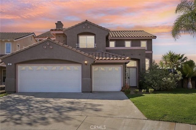 mediterranean / spanish-style house with driveway, an attached garage, and stucco siding