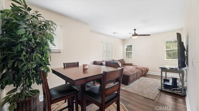 dining room with a ceiling fan, visible vents, wood finished floors, and baseboards