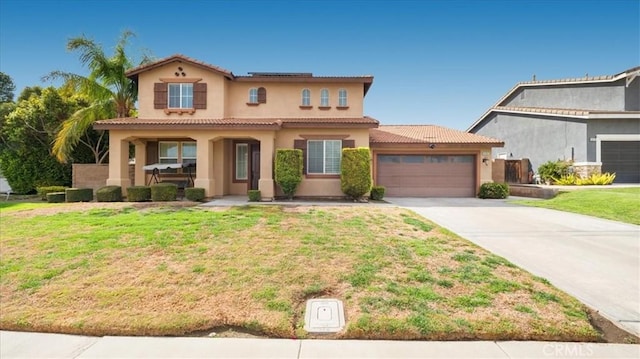 mediterranean / spanish house with a garage, a front lawn, and a tiled roof