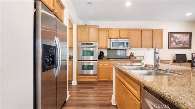 kitchen with recessed lighting, a sink, light brown cabinetry, dark wood-type flooring, and stainless steel appliances