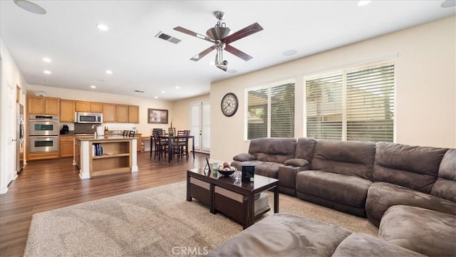 living room featuring plenty of natural light, recessed lighting, visible vents, and wood finished floors