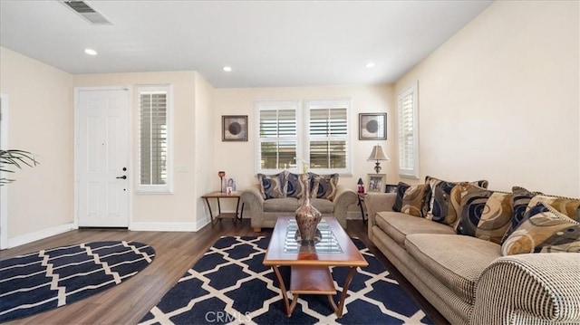 living area with recessed lighting, wood finished floors, visible vents, and baseboards